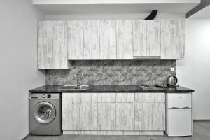 a kitchen with a sink and a washing machine at Near the airport in Zvartnots International Airport