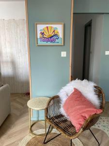 una sedia di vimini con un cuscino in una stanza di .Surfin' La Chaume. a La Chaume