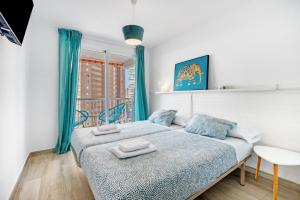 a bedroom with a bed with two towels on it at Apartmento Benidorm in Benidorm