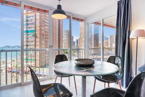 a dining room with a table and chairs and a balcony at Apartmento Benidorm in Benidorm