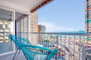 a blue chair on a balcony with a view of a city at Apartmento Benidorm in Benidorm