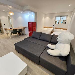 Ein großer weißer Teddybär sitzt auf einem Sofa im Wohnzimmer. in der Unterkunft Kgolmok house in Daejeon