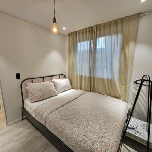 ein Schlafzimmer mit einem Bett und einem Fenster mit Vorhängen in der Unterkunft Kgolmok house in Daejeon