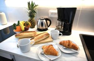 a table with cups and croissants on a counter at Paris vous aime in Le Kremlin-Bicêtre