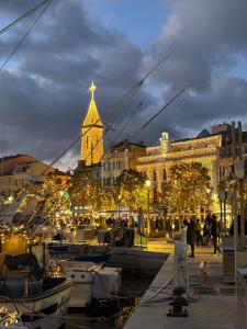 Un puerto con barcos y un edificio con luces navideñas. en Magnifique appartement vue mer Sanary-sur-mer, en Sanary-sur-Mer