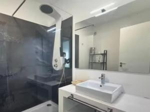 un bagno con lavandino, doccia e specchio di Tranquil Escape a Gaula Altre 11 foto