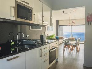 una cucina con un lavello e un tavolo con sedie di Tranquil Escape a Gaula