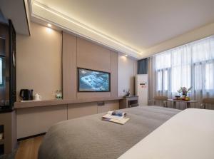 una habitación de hotel con cama y televisor de pantalla plana en Avator Yiyun Hotel Zhangjiajie National Forest Park, en Zhangjiajie