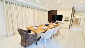 een eetkamer met een houten tafel en stoelen bij Melodia V in Durban