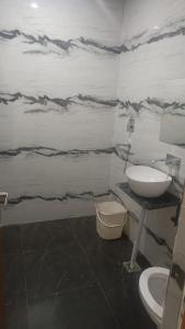 een badkamer met een wastafel en een toilet bij Hotel Ashoka in Karnāl