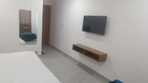een kamer met een bed en een tv aan de muur bij Hotel Ashoka in Karnāl