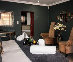 Zimmer mit einem Bett und einem Tisch mit Blumen in der Unterkunft Vaal De Vue Guesthouse in Christiana + 43 Fotos