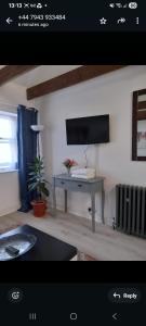 Una sala de estar con una mesa y un televisor. en Number Four, en Brighton & Hove