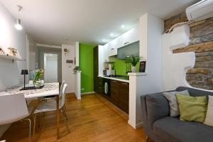 a kitchen and living room with a table and a couch at La Tana di Alice in Muggia