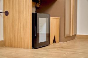 einem schwarzen Kühlschrank in der Ecke eines Zimmers in der Unterkunft Guest House Aura - Lumys Fiumicino in Fiumicino