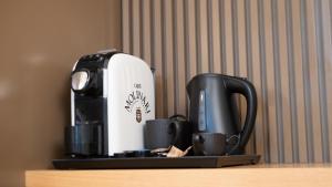 eine Kaffeemaschine und Kaffeetassen auf dem Tisch in der Unterkunft Guest House Aura - Lumys Fiumicino in Fiumicino