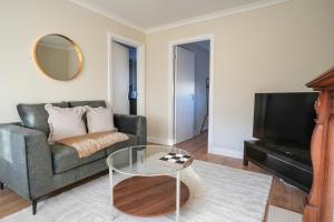 een woonkamer met een bank en een televisie bij 4 BDR House At Caledonia Luxe Stays Short Lets & Serviced Accommodation Bo'ness in Boʼness