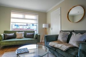 een woonkamer met twee groene banken en een glazen tafel bij 4 BDR House At Caledonia Luxe Stays Short Lets & Serviced Accommodation Bo'ness in Boʼness +33 foto's