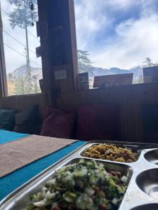 Una bandeja de comida sobre una mesa con un plato de comida. en Oreos cafe and stay shangarh, en Shangarh