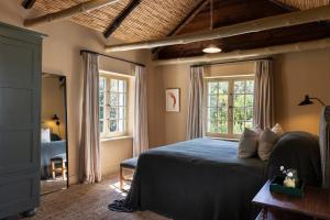 a bedroom with a bed and two windows at Boschendal Farm Estate in Franschhoek +205 photos
