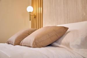 ein Bett mit zwei Kissen darauf in der Unterkunft Guest House Aura - Lumys Fiumicino in Fiumicino + 64 Fotos