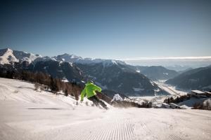 a person is skiing down a snow covered mountain at Posthof - Alpine Living Apartments in Campo di Trens