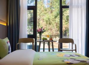 Un dormitorio con una cama y sillas y una mesa y una ventana. en Avator Yiyun Hotel Zhangjiajie National Forest Park, en Zhangjiajie