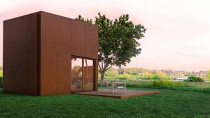 un bâtiment sur un champ herbeux avec un arbre dans l'établissement Oseraie Cabins - Wild lodges près de Maastricht, à Visé