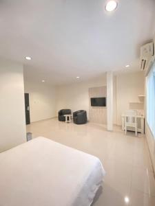 una camera bianca con letto e soggiorno di Hotel Beverly Inn Batam Center a Batam Center