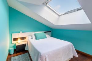 una camera da letto con un letto con una parete blu di Espectacular dúplex en Cartes a Cartes