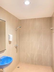 bagno con doccia e lavandino blu di Hotel Beverly Inn Batam Center a Batam Center