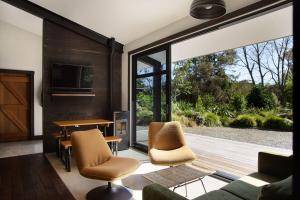 a living room with a sliding glass door and a table and chairs at Minden Retreat in Te Puna