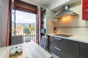 una cucina con un tavolo e una finestra con vista di Espectacular dúplex en Cartes a Cartes