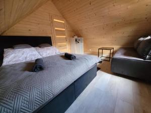 a bedroom with two beds and a couch in a attic at Agroturystyka Lawendowa Dolinka Domki Beskid Niski in Chyrowa