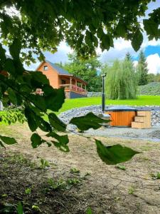 a house in the distance with a building in the background at Agroturystyka Lawendowa Dolinka Domki Beskid Niski in Chyrowa