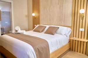 une chambre avec un grand lit avec des draps blancs dans l'établissement Guest House Aura - Lumys Fiumicino, à Isola Sacra
