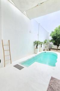 a swimming pool in a room with white walls and a white ceiling at Floraison Living Villa Yogyakarta in Ngaglik +56 photos