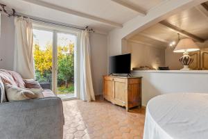 L'Arbousier في Laouque: غرفة معيشة مع سرير وتلفزيون