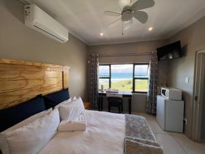 Un dormitorio con una cama y un escritorio con una computadora. en La Vue, en Port Shepstone 32 fotos más