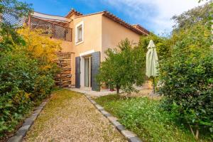 L'Arbousier في Laouque: منزل فيه مظله وحديقة