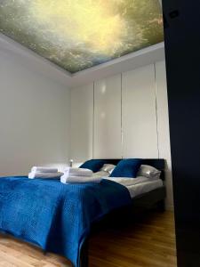 a bedroom with a bed with a painting on the ceiling at Jacuzzi & Parking Piernikowy Spa Apartment by Rentoom in Toruń