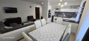 a kitchen and living room with a table and a couch at Apartmán u Jeleňa in Kežmarok