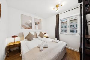a white bedroom with a bed and a window at Casa Tantris zentral und modern mitten in Gmund in Gmund am Tegernsee