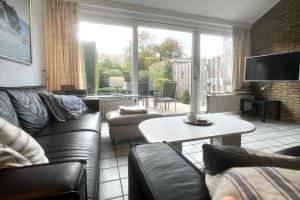 ein Wohnzimmer mit Sofa und Tisch in der Unterkunft De Vuurtoren, Lijsterstraat 12 in Tiel