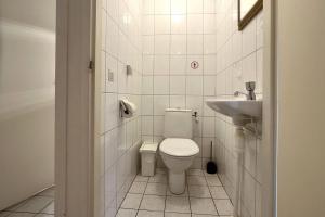 ein weißes Badezimmer mit Toilette und Waschbecken in der Unterkunft De Vuurtoren, Lijsterstraat 12 in Tiel + 10 Fotos