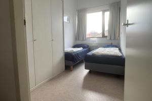 ein kleines Zimmer mit zwei Betten und einem Fenster in der Unterkunft De Vuurtoren, Lijsterstraat 12 in Tiel