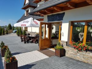 a building with a restaurant with a table and chairs at Willa Silene - góralska muzyka na żywo i bezpłatne rowery do wypożyczenia in Bukowina Tatrzańska