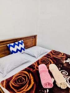 Una cama con dos pares de zapatillas. en Rashmika Homestay, en Nallathanniya
