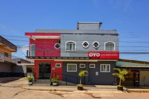 a red and gray building with aoops sign on it at OYO Hotel Brisa Tropical, Brasília in Brasília