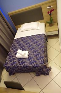 Un dormitorio con una cama con una manta de rayas moradas. en Hotel V7, en Milán